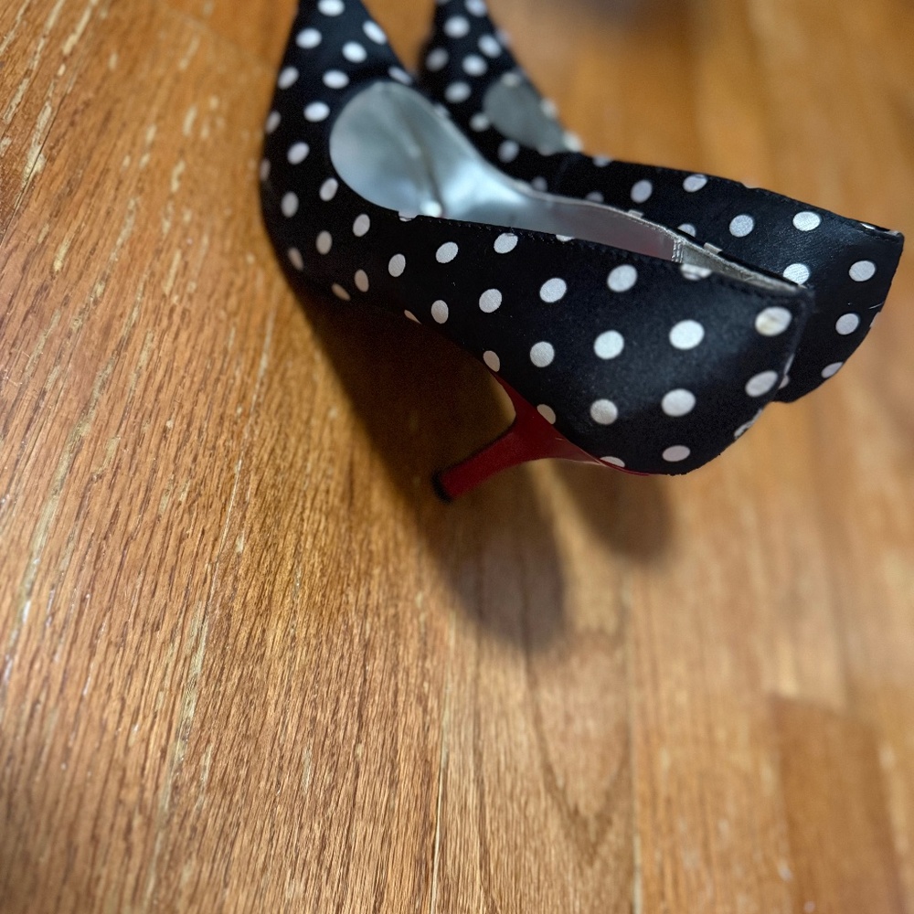 Black and white poke a dot shoes with red heel.